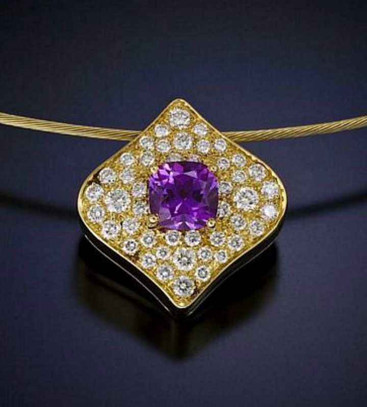 Gold pendant with purple sapphire and on a field of pave diamonds